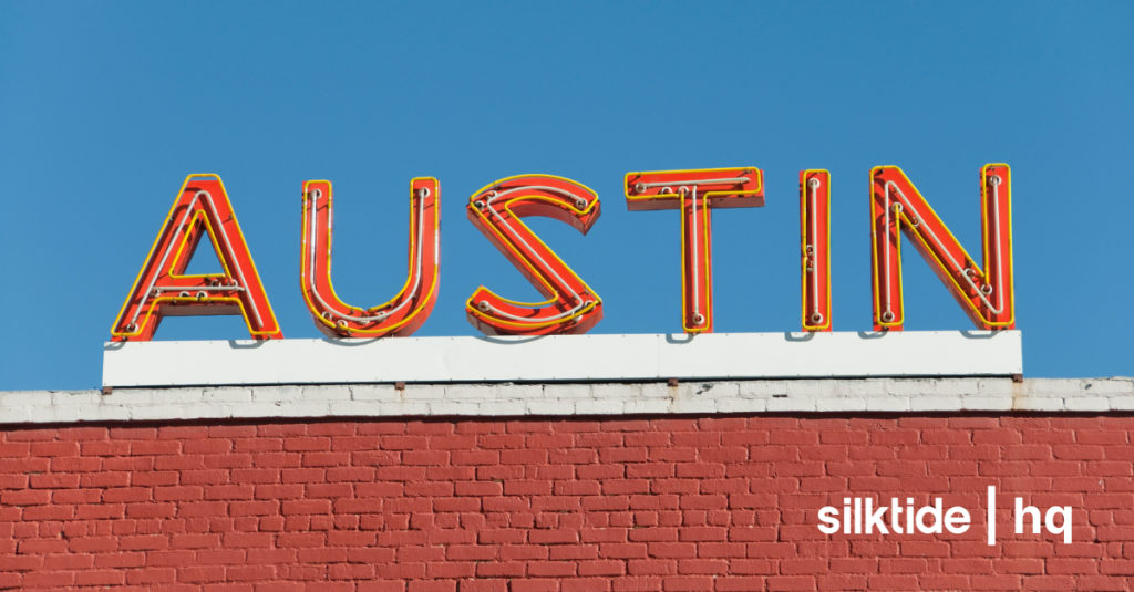 Bright neon ‘Austin’ sign on a red brick wall, reflecting the city’s bold, vibrant character.